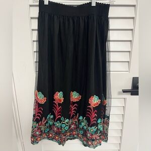 A black chiffon skirt with design on the bottom.
